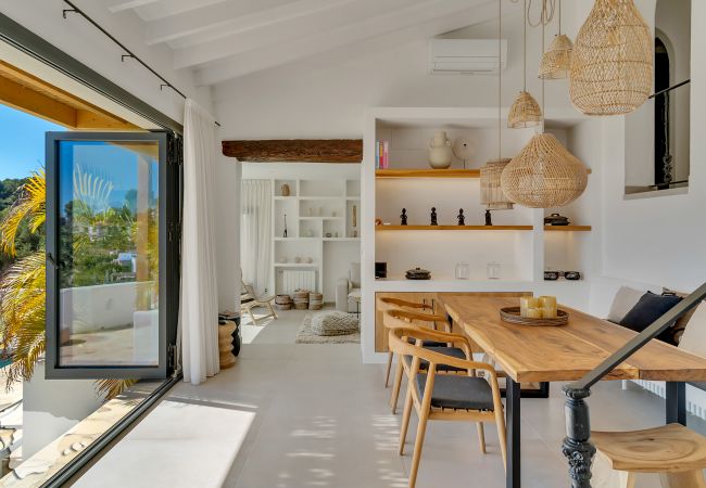 Geniet van de eethoek in Ibiza-stijl, bij de open keuken met openslaande deuren naar de tuin en zwembad.